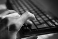 Female hand is typing on the keyboard, selective focus, bw photo Royalty Free Stock Photo