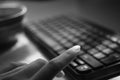 Female hand is typing on the keyboard, selective focus on the finger, bw photo Royalty Free Stock Photo