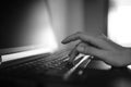 Female hand typing on a laptop keyboard. BW photo Royalty Free Stock Photo