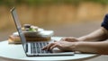 Female hand typing on laptop keyboard on coffee table in garden at home Royalty Free Stock Photo