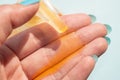 Female hand uses orange liquid soap with a dispenser