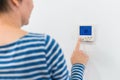 Female hand using of home heating and cooling system control unit Royalty Free Stock Photo