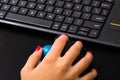 Female hand using pc mouse and keyboard. Close up woman hand on computer mouse and keyboard on black wooden background Royalty Free Stock Photo