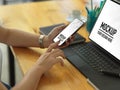 Female hand using smartphone while working with tablet on wooden table Royalty Free Stock Photo