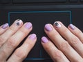 Female hand is using a touchpad on a laptop close up. Creative manicure on the theme of coronavirus Royalty Free Stock Photo