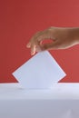 Female Hand Voting Near Ballot Box on Red Background