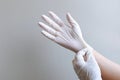 Female hand wearing white latex gloves