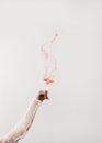 Female hand swirling glass of rose wine making splash