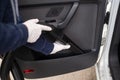 Female hand in white gloves hoovering a car cabin