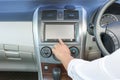 Female hand with white shirt pushing the power button to turn on the car radio Royalty Free Stock Photo