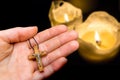 Female hand with wooden cross on candles background Royalty Free Stock Photo