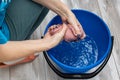 female hand wringing out a rag in a bucket while cleaning