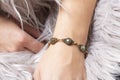 wrist wearing brass golden bracelet with mineral stone