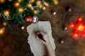 female hand writes letter dear santa on a wooden background with the numbers 2021, a blank sheet of paper, covid-19 vaccine, led Royalty Free Stock Photo