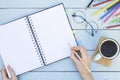 Female hand writing blank notebook on wooden table. Study desk. Royalty Free Stock Photo