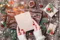 Female hand writing a letter to Santa on wooden background with Christmas gifts, bark texture, Fir branches Royalty Free Stock Photo