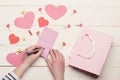 Female hand writing love message on pink note paper Royalty Free Stock Photo