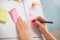 Female hand writing on post it notes. Royalty Free Stock Photo