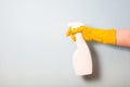 female hand in a yellow rubber glove holds a white spray bottle Royalty Free Stock Photo