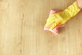 Female hand in a yellow rubber glove washes a wooden parquet floor with a pink microfiber cloth Royalty Free Stock Photo