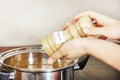 Female hands add to the pot the seasoning Royalty Free Stock Photo