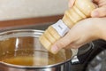 Female hands add to the pot the seasoning Royalty Free Stock Photo