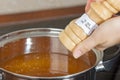 Female hands add to the pot the seasoning Royalty Free Stock Photo