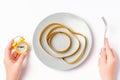 Female hands with an alarm clock and an empty plate with a centimeter tape on white background close-up top view. Royalty Free Stock Photo