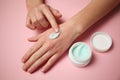 Female hands apply moisturizer to the skin. Irritation and allergies, frostbite