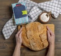 Female hands around a round loaf of white bread with flour in a bag and bowl Royalty Free Stock Photo