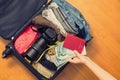 Female hands with Asian money and foreign passport. Suitcase with things on the floor. Travel concept Royalty Free Stock Photo