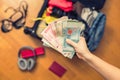 Female hands with Asian money and foreign passport. Suitcase with things on the floor. Travel concept Royalty Free Stock Photo