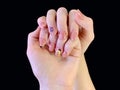 Female hands with a beautiful manicure, on a black background. Hands of a young girl, with manicured nails. The fingers of a young