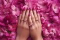 Female hands with beautiful manicure and flowers on red background, top view