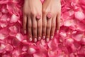 Female hands with beautiful manicure and flowers on red background, top view