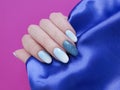 Female hands beautiful manicure, silk fabric Royalty Free Stock Photo