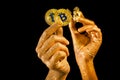 Female hands with bitcoins and gold nuggets on black background
