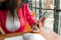 Female hands with a black phone, close-up, background of a cup of coffee, table, notebook. Business lunch Royalty Free Stock Photo