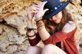 Female hands with boho chic bracelets holding black hat