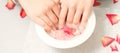 Female hands in bowl with rose petals Royalty Free Stock Photo