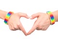 Female hands with a bracelet patterned as the rainbow flag showing heart sign. on white Royalty Free Stock Photo