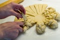 Female hands braiding, decorating dough on white kitchen table Royalty Free Stock Photo