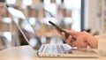 Female Hands Browsing Smartphone next to Laptop, Close up Royalty Free Stock Photo