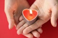 In female hands burning candle in form of heart Royalty Free Stock Photo