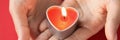 In female hands burning candle in form of heart Royalty Free Stock Photo