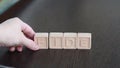 Female hands change first letter in word bide so that it turns to fide. Concept