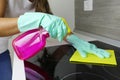 Female hands cleaning a modern black induction hob by a rag and spray Royalty Free Stock Photo