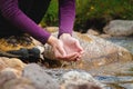 female hands close-up draw water from a mountain stream to quench thirst, drink from a clean source of water. tourist on Royalty Free Stock Photo