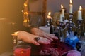 Female hands close-up, session of magic in dark room of fortuneteller, magic items on table, esoteric Oracle, divination for Royalty Free Stock Photo