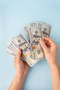 Female hands counting 100 dollar bills isolated on a blue background. Royalty Free Stock Photo